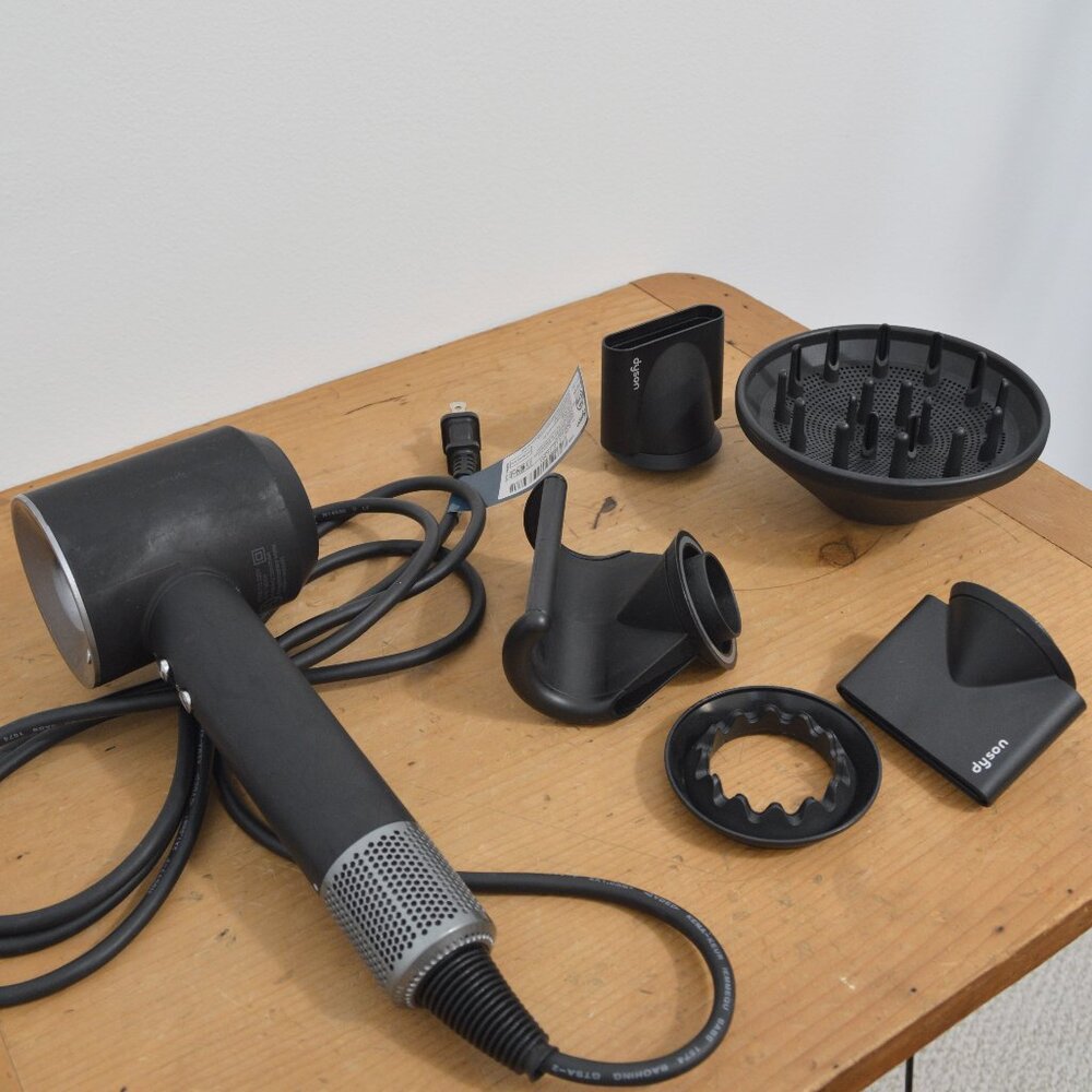 black dyson hair dryer with all the accesories
